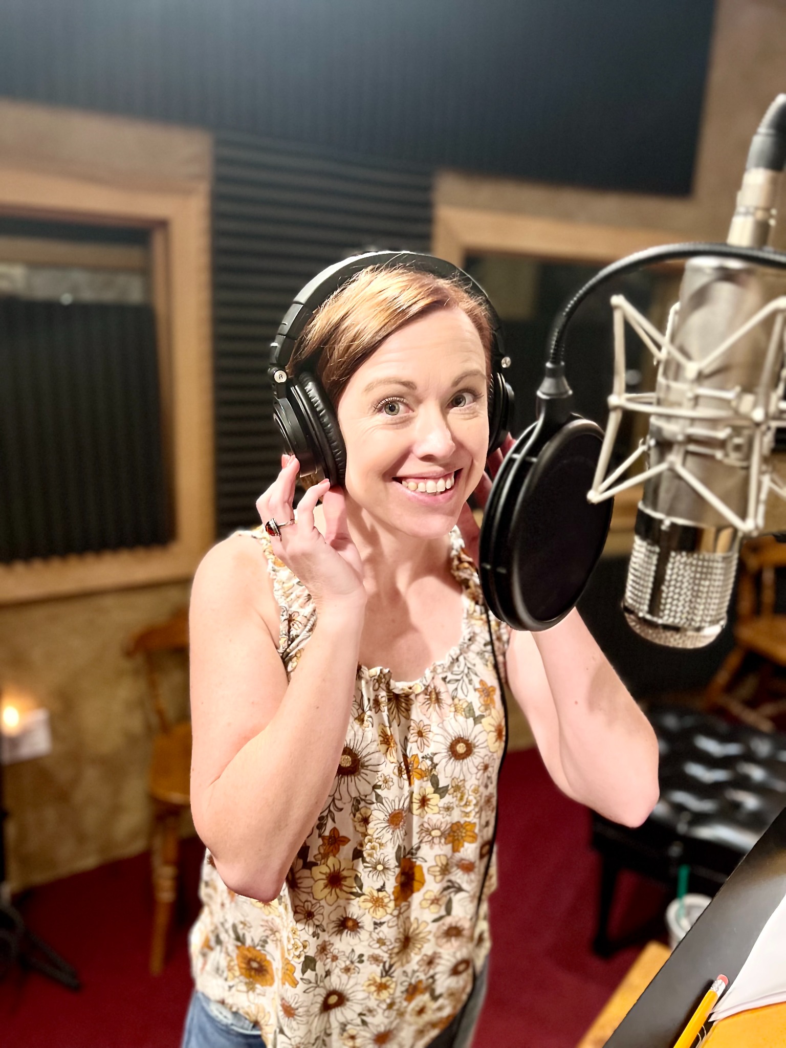Amber Pennington wearing headphones at a studio microphone